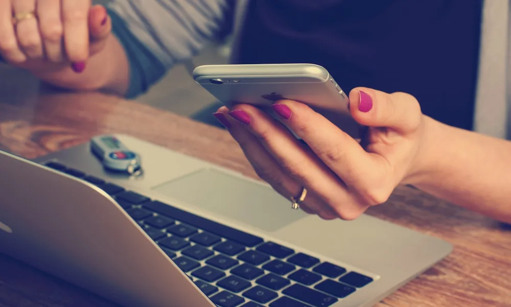 A business owner working discreetly on a phone and laptop, keeping a facility confidential