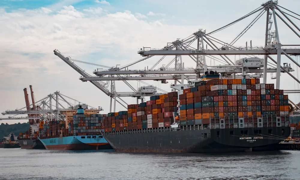 A cargo ship loading at port, representing funding for export invoices to overseas customers