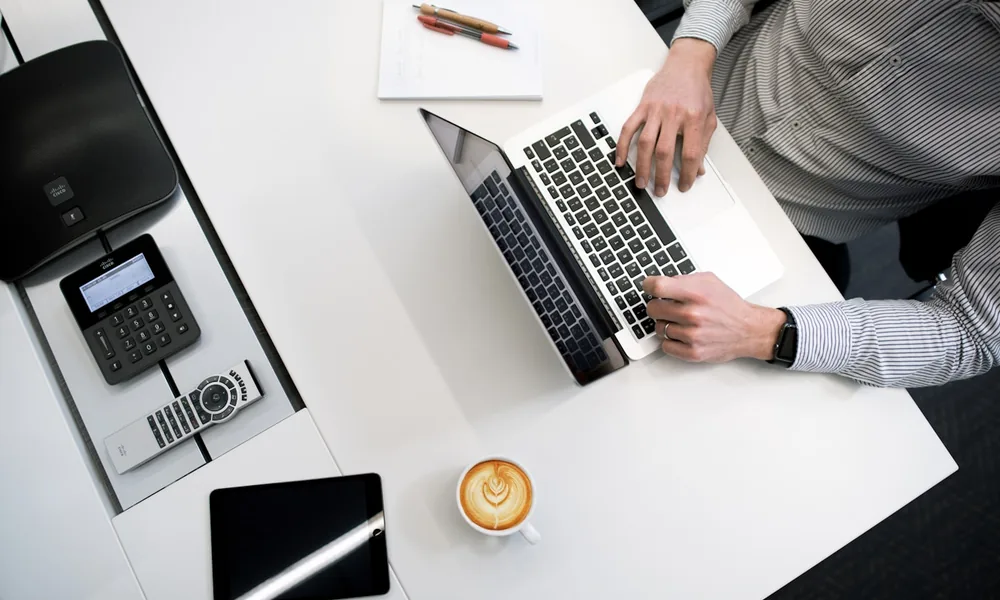 Two colleagues working through the invoice finance process at a desk with a laptop