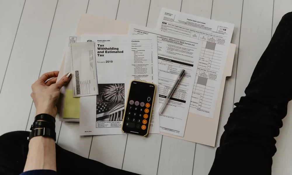 Invoices, a calculator and paperwork on a desk, working out the cost of invoice finance