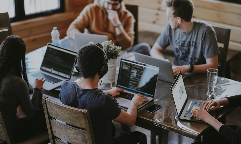 A young company team working together on laptops in a startup office