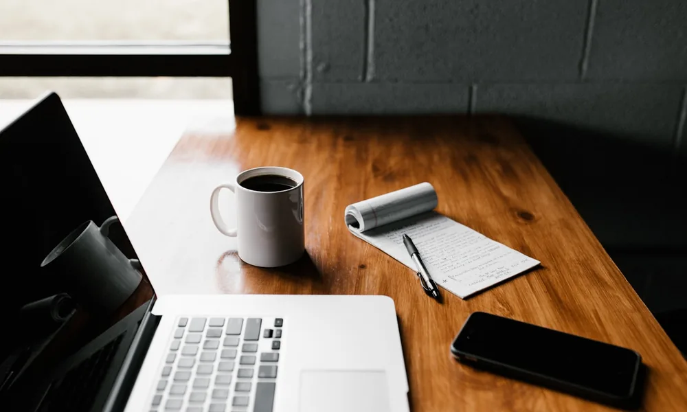 A tidy desk with a laptop, where a business owner weighs up whether invoice finance fits